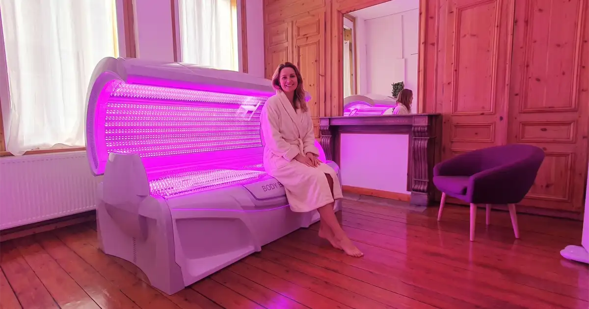 Cliente assise sur la cabine de photobiomodulation Body Boost Bed